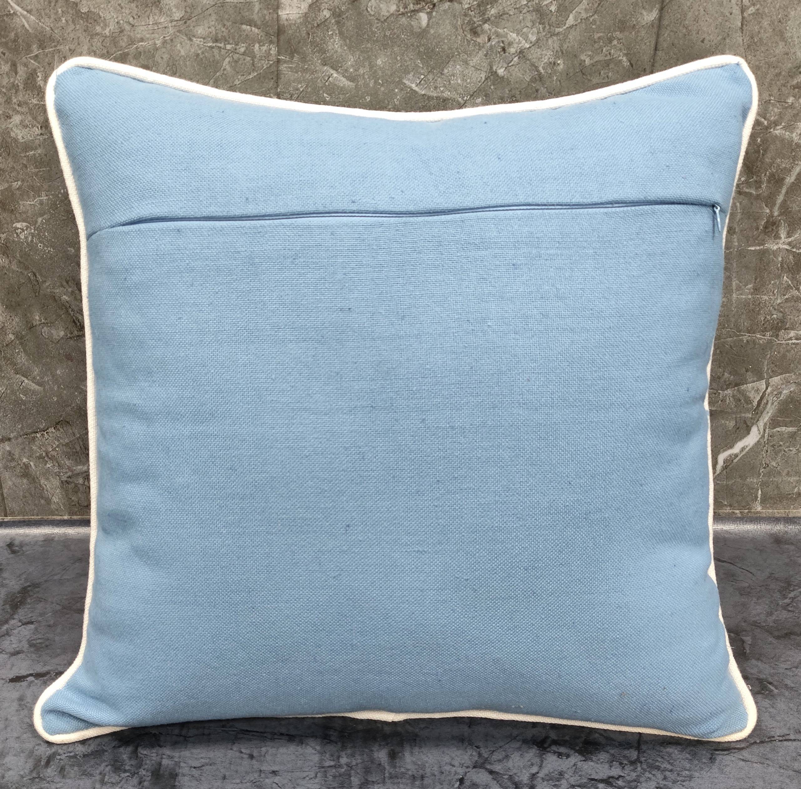 Pillow featuring a slub woven cover in soft blue with cream piping, ideal for stylish home décor.