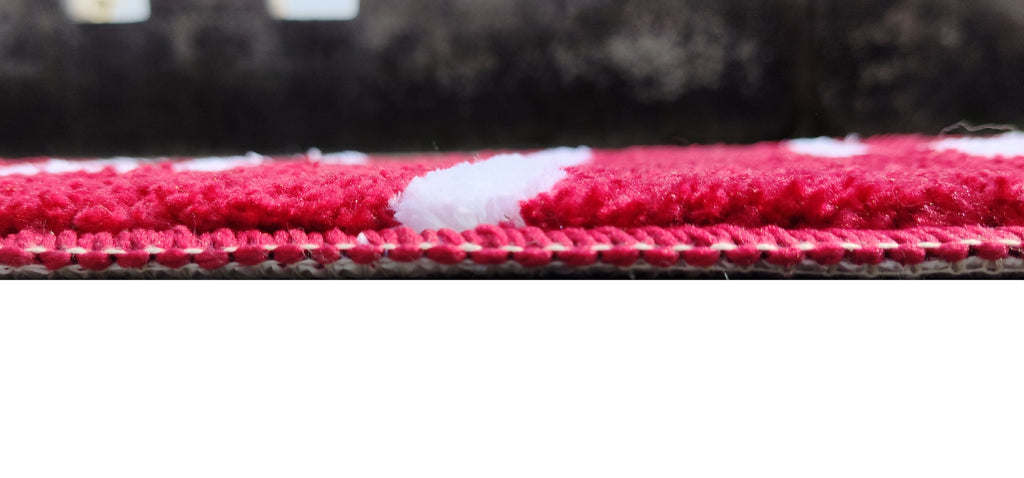 Close-up view of a modern rug with red and white stripes, showcasing the texture of the microfiber material.