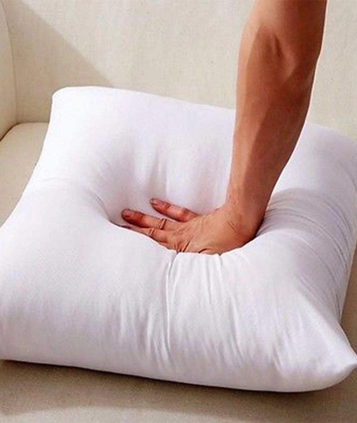 Hand pressing on soft white Floor Cushion, showcasing comfort and plush texture of the Pillow.